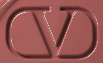 Close-up of a smooth, chocolate-brown surface featuring an embossed logo with the letters "CD" intertwined.
