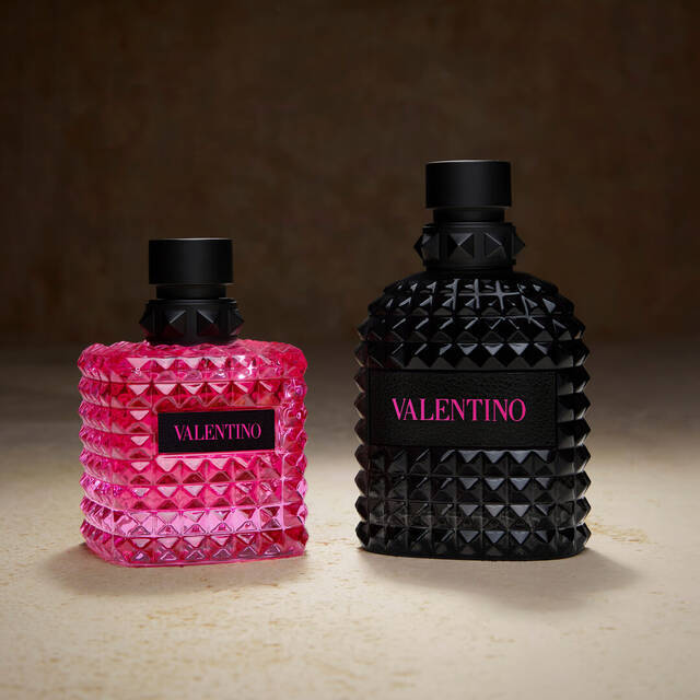 Twee Valentino parfums, een roze en een zwarte fles, staan naast elkaar op een neutrale achtergrond.